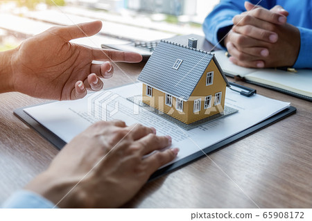 House model with agent and customer discussing for contract to buy, get insurance or loan estate. 65908172