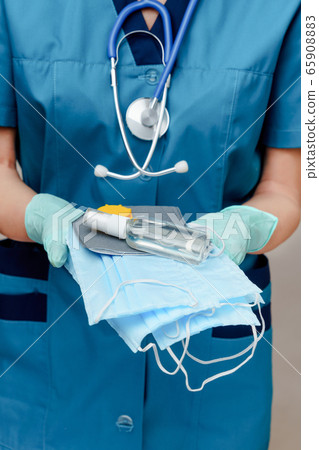 medical doctor nurse woman with stethoscope - holding protective mask and sanitizer 65908883