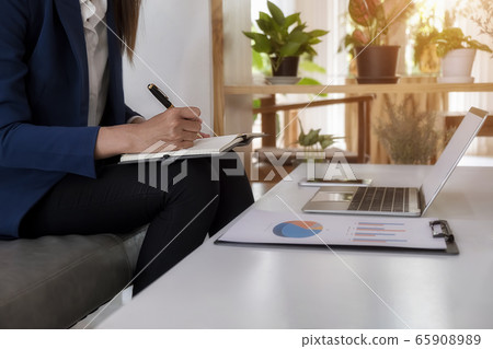 Business woman discussing the charts and graphs showing the results of their successful teamwork. 65908989