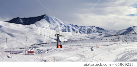 Ski slope with surface lift and gray sky 65909235