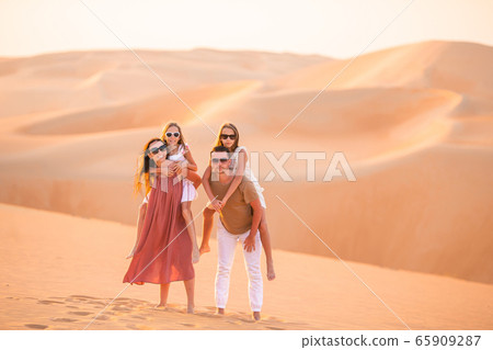 Girls among dunes in Rub al-Khali desert in United Arab Emirates Girls among dunes in Rub al-Khali desert in United Arab Emirates 65909287