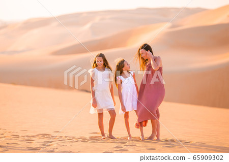 People among dunes in Rub al-Khali desert in United Arab Emirates People among dunes in Rub al-Khali desert in United Arab Emirates 65909302