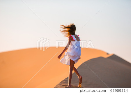 Girl among dunes in Rub al-Khali desert in United Arab Emirates 65909314