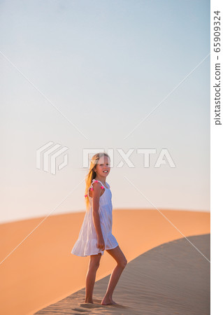 Girl among dunes in desert in United Arab Emirates 65909324