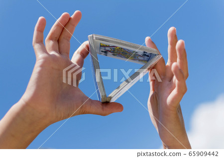 Hand and playing cards over sky background Hand and playing cards over sky background 65909442