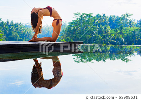 Young yoga woman stretching back in ustrasana Young yoga woman stretching back in ustrasana 65909631