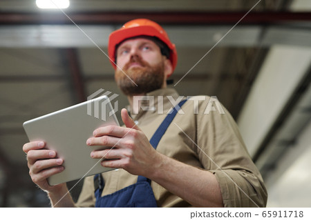 Engineer using tablet at factory 65911718