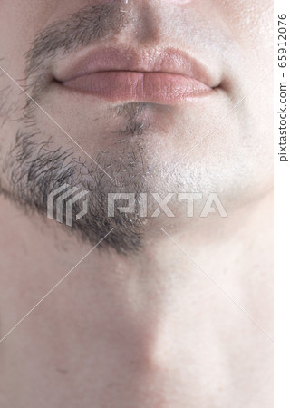 A close-up of a man's half-shaven chin. Man shaving concept. 65912076