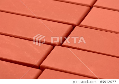 A stack of bricks for construction, hollow brick. Material for construction and repair. Clay brick, brick texture, preparation for the construction process 65912077