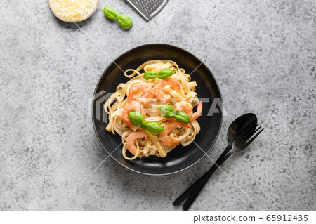 Italian pasta fettuccine with shrimps on grey. Italian pasta fettuccine with shrimps on grey. 65912435