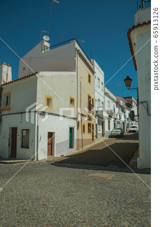Old terraced houses with cracked plaster in Campo Maior 65913126
