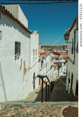 Alley going down the slope with steps among houses in Campo Maior Alley going down the slope with steps among houses in Campo Maior 65913128