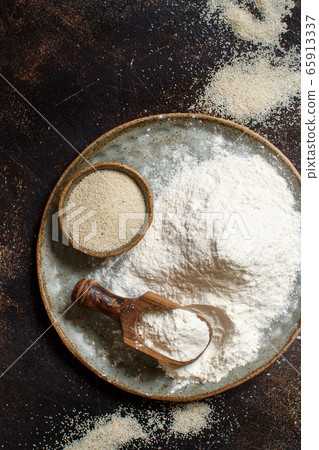 Raw fonio flour and seeds with a spoon on a plate 65913337