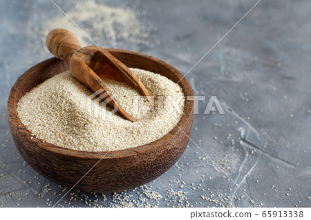Raw fonio seeds in a bowl with a spoon Raw fonio seeds in a bowl with a spoon 65913338