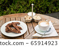 a plate of homemade chocolate biscotti cookies and a Cup of coffee with cream and sugar on the table. Blurred background 65914923
