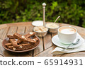 A plate of homemade chocolate biscotti and a Cup of coffee with cream and sugar on the wooden table. Blured backgroung 65914931