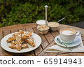 a plate of homemade biscotti cookies and a Cup of coffee with cream and sugar on the wooden table. Blurred background 65914943