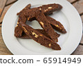 chocolate Homemade biscotti cookies with white chocolate on a white plate on a wooden table 65914949