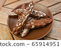 chocolate homemade biscotti cookies with white and dark chocolate on a brown plate on a wooden table 65914951