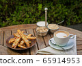 a plate of homemade biscotti cookies and a Cup of coffee with cream and sugar on the wooden table. Blurred background 65914953