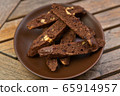 homemade chocolate biscotti with nuts and raisins on a brown plate on a wooden table 65914957