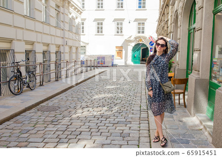 Woman walking in city. Young attractive tourist outdoors in italian city 65915451