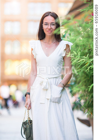 Woman walking in city. Young attractive tourist outdoors in european city Woman walking in city. Young attractive tourist outdoors in european city 65916089