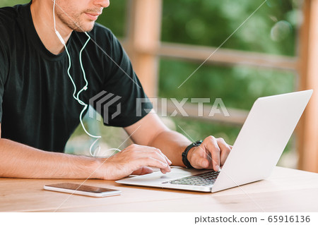 Young man with laptop works from home Young man with laptop works from home 65916136