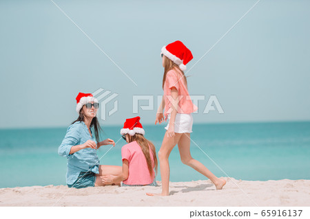 Adorable little girls and young mother on tropical white beach Adorable little girls and young mother on tropical white beach 65916137