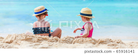Two kids making sand castle and having fun at tropical beach 65916141