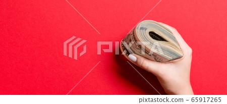 Female hand holding tightly a bundle of money. Top 65917265