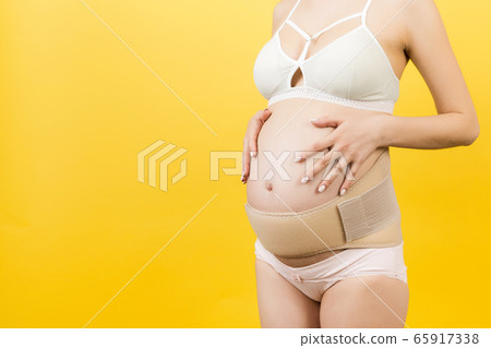 Close up of pregnant woman in underwear using Close up of pregnant woman in underwear using 65917338