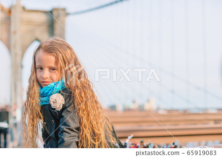 Adorable little girl sitting at Brooklyn Bridge in New York Adorable little girl sitting at Brooklyn Bridge in New York 65919083