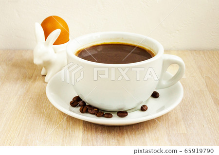 Coffee cup, saucer, beans, rabbit egg holder. Easter breakfast concept 65919790