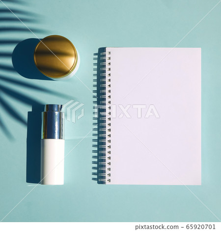 Cosmetic natural products on pastel blue background. Notebook for inscription 65920701