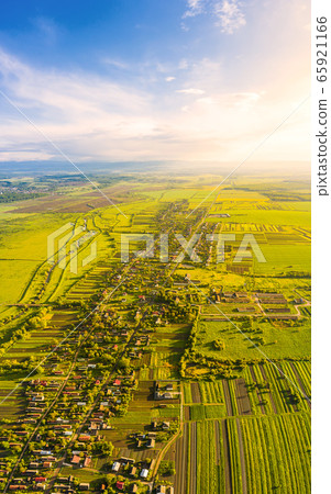 Scenic aerial drone view of countryside. Soft sunlight illuminates blue sky, green meadows and village. Vertical panoramic landscape from birds-eye view Scenic aerial drone view of countryside. Soft sunlight illuminates blue sky, green meadows and village. Vertical panoramic landscape from birds-eye view 65921166