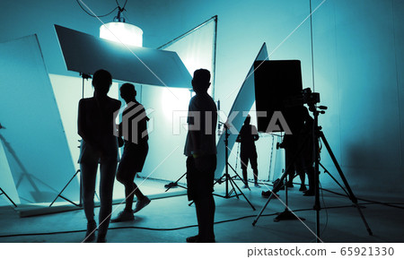 Shooting studio for photographer and creative art director with production crew team setting up lighting flash and LED headlight on tripod and professional equipment for portrait model photo shoot 65921330