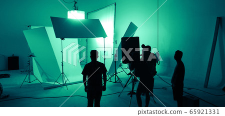 Shooting studio for photographer and creative art director with production crew team setting up lighting flash and LED headlight on tripod and professional equipment for portrait model photo shoot 65921331