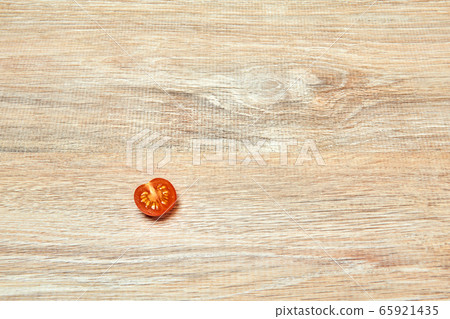 lone half cherry tomato on a wooden table surface lone half cherry tomato on a wooden table surface 65921435