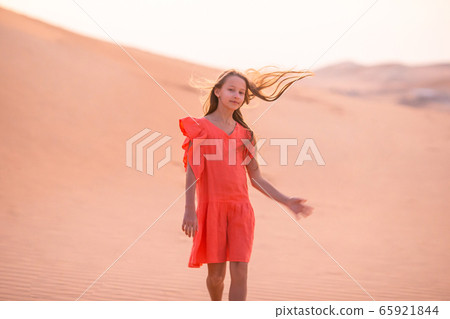 Girl among dunes in Rub al-Khali desert in United Arab Emirates 65921844