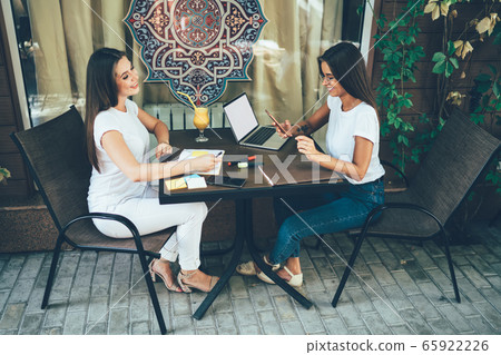Female colleagues meeting in cafe for discussion project 65922226