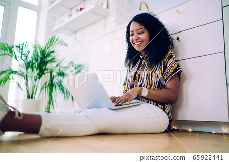 Laughing black woman working remotely at home 65922441