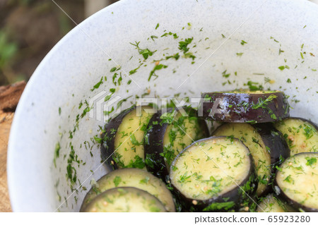 in a bowl, raw, struck eggplant in a marinade with herbs, dill in a rustic natural form. Preparation in a bowl, raw, struck eggplant in a marinade with herbs, dill in a rustic natural form. Preparation 65923280