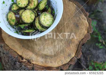 in a bowl, raw, struck eggplant in a marinade with herbs, dill in a rustic natural form. Preparation in a bowl, raw, struck eggplant in a marinade with herbs, dill in a rustic natural form. Preparation 65923285