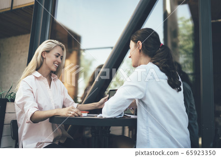 Female colleagues discussing work during lunch break 65923350