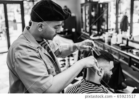 Classic haircut in a barbershop. Curve hair styling and hair health care in a barbershop.  65923517