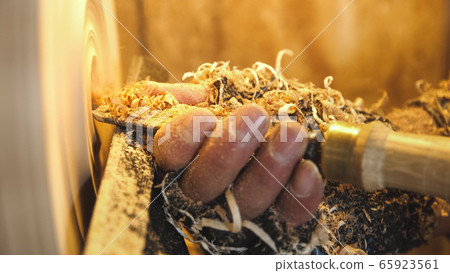 Woodworker handles product by lathe and graver. Woodworker handles product by lathe and graver. 65923561