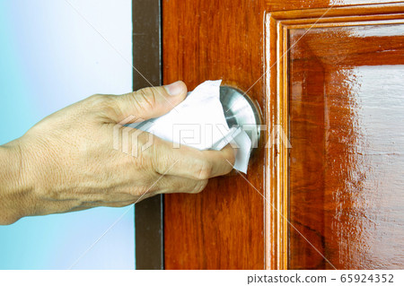 Prevention cleaning Door handles by Disinfectant solution for killing corona virus on touching surfaces, concept coronavirus COVID19. Prevention cleaning Door handles by Disinfectant solution for killing corona virus on touching surfaces, concept coronavirus COVID19. 65924352