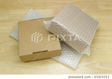 Bubbles covering the box by bubble wrap for protection product cracked on wood table 65924353