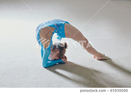 A girl in a tracksuit does a stretch. Gymnast goes in for sports. Healthy lifestyle concept, sports uniforms, world Cup, gym, specialized clothing, uniforms 65930080